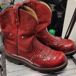 Pair of red leather cowboy boots with intricate detailing.