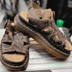 Brown leather sandals with yellow stitching.