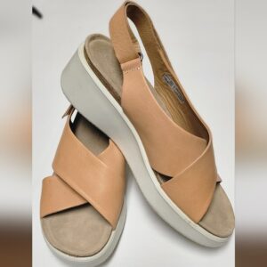 Beige platform sandals with crisscross straps on a white background.