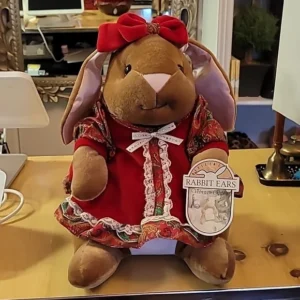 Plush bunny dressed in red Victorian-style dress with a tag.