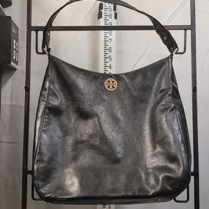 Black leather shoulder bag with a gold emblem on the front.