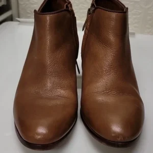 Pair of brown leather ankle boots on a white surface.