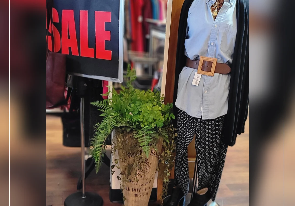 Mannequin with sale sign in clothing store.